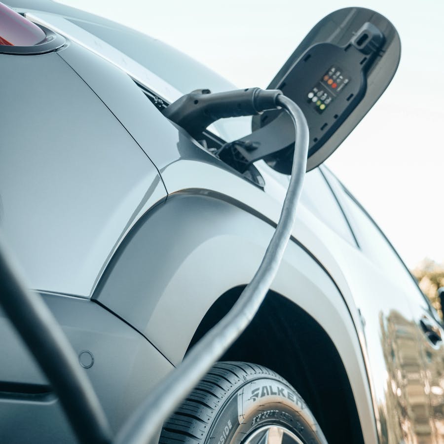 Electric vehicle connected to a public charging station in a close-up charging scene