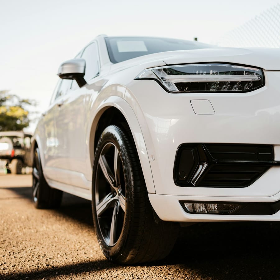White luxury SUV parked outdoors on a sunny day in a close front exterior view