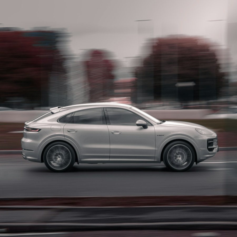 Silver luxury SUV driving on a city street in a tight motion-style exterior close-up