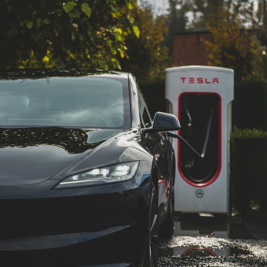 Electric car at a Tesla-style charging station in a close exterior charging scene