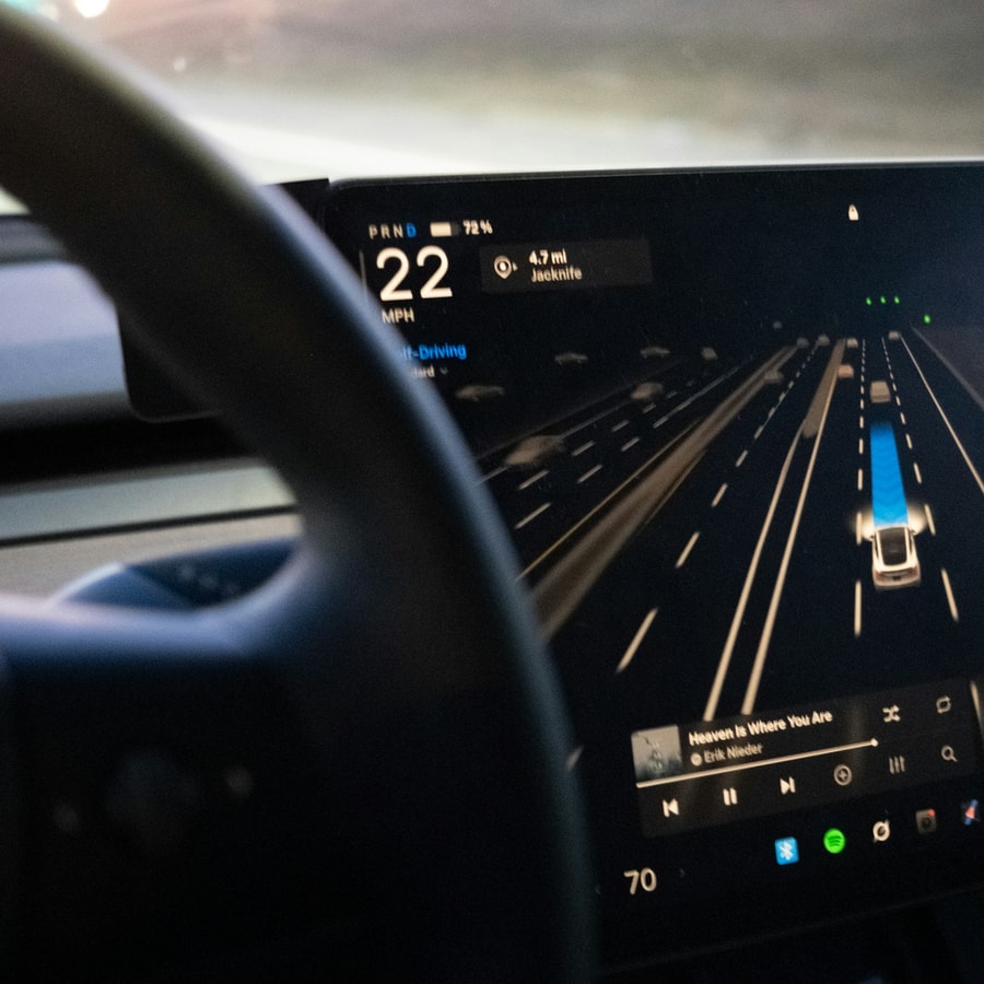Car dashboard with large center touchscreen showing driving interface in a close interior view