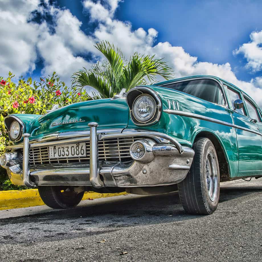 Classic blue sedan parked on a street in a tight front exterior close-up