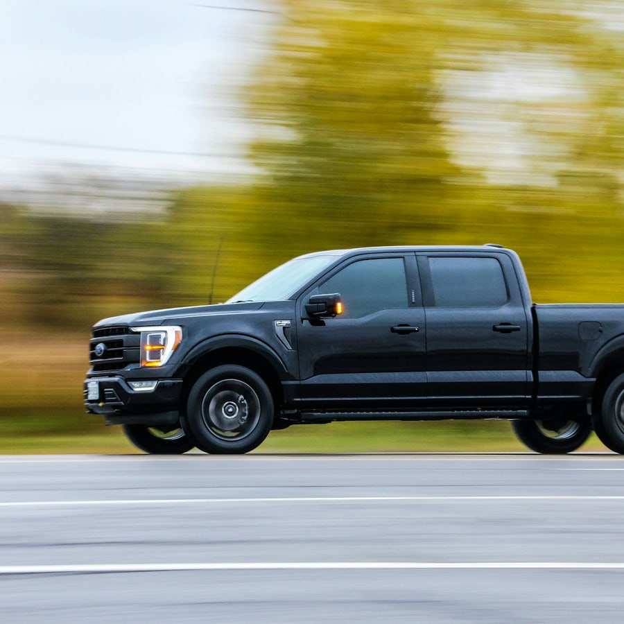 Black full-size pickup truck on a paved road in a tight front exterior close-up