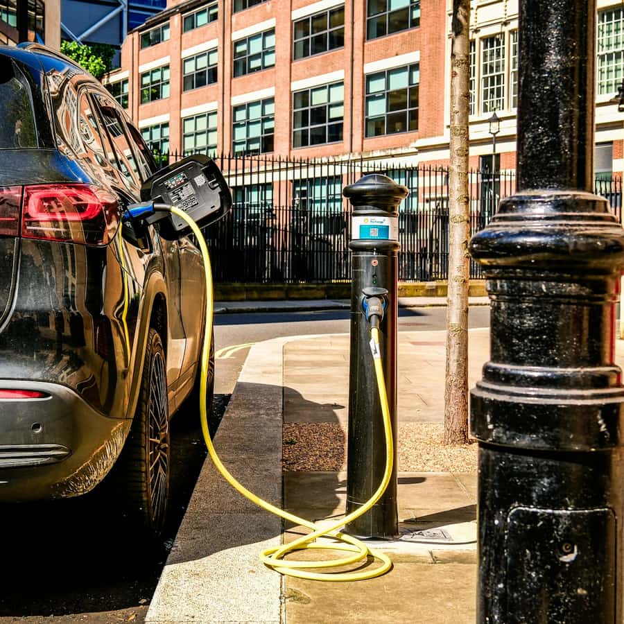 Electric sedan at a public charger shown in a tight close-up of the cable and port